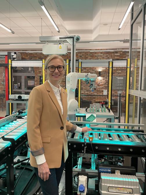 Dr Anita Pollak stoi w laboratorium obok maszyny 