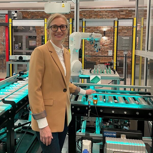 Dr Anita Pollak stoi w laboratorium obok maszyny