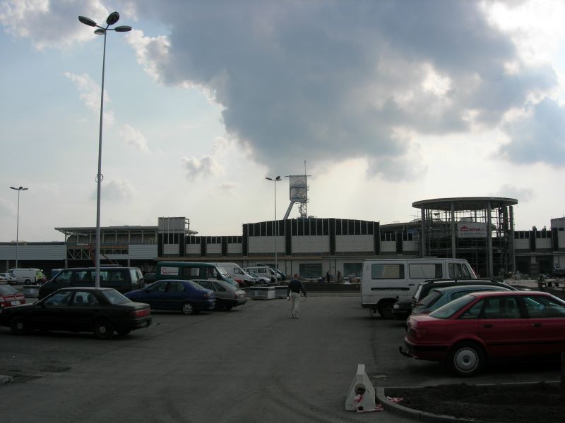 Silesia City Center w trakcie budowy, na parkingu stoi sporo samochodów, w oddali budynek w budowie