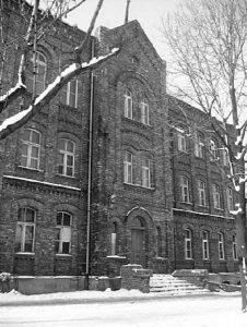 stary trzypętrowy budynek z cegły, zdjęcie czarno-białe