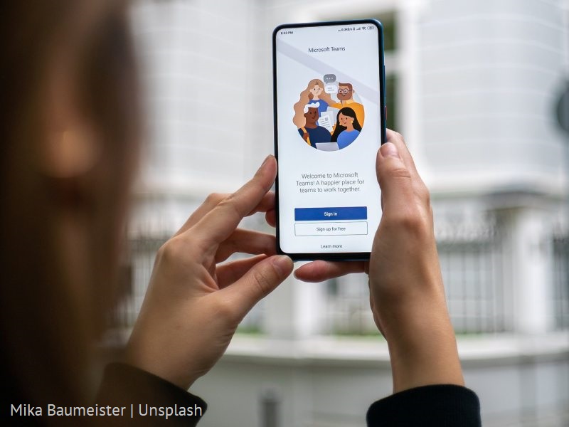 Kobieta trzymająca telefon z uruchomioną aplikacją MS Teams