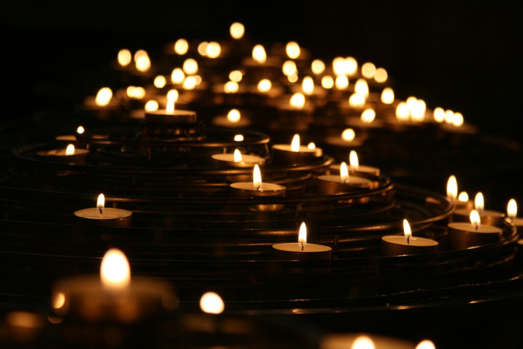 pexels-candlelights-1868525 Zapalone świece wotywne w półmroku, symbolizujące pamięć, modlitwę i zadumę