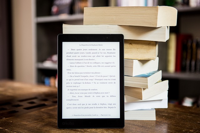 czytnik ebook na tle stosu książek