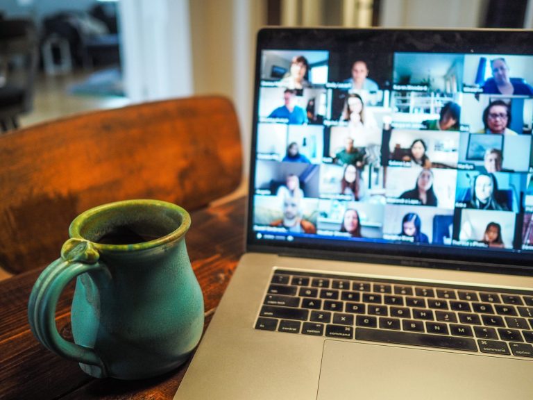 zdjęcie przedstawiające laptop ze spotkaniem online i kubek