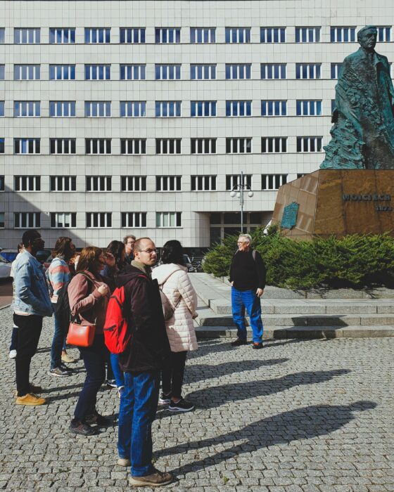Group of people in front of the monument of Wojciech Korfanty. Grupa ludzi stojąca z przewodnikiem przed pomnikiem Wojciecha Korfantego