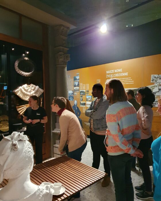 Excursion participants on a guided tour in front of exhibits in the Muzeum Śląskie.Uczestnicy wycieczki zwiedzający z przewodniczką Muzeum Śląskie stojący przed gablotą z eksponatami