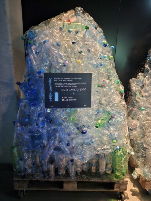 A heap of empty plastic bottles standing in the water museum. Stos pustych plastikowych butelek sklejony folią stojący w muzeum wody.