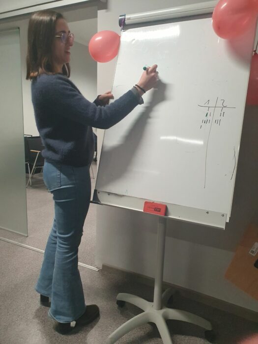 A women drawing with a marker on a whiteboard. Kobieta rysująca markerem na białej tablicy.