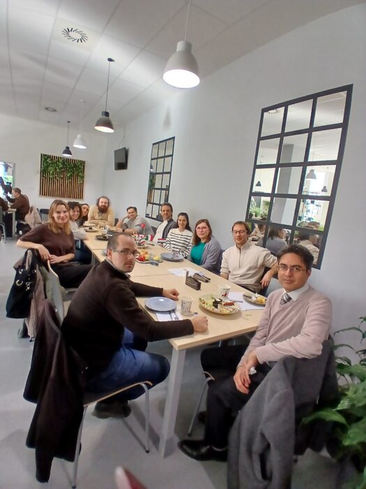A group of people sitting at the table. Grupa ludzi siedząca przy stole.