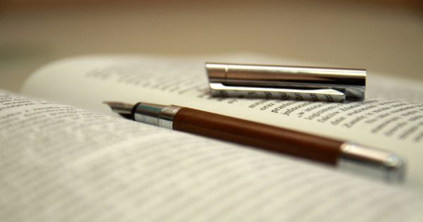 Pióro leżące na otwartej książce 