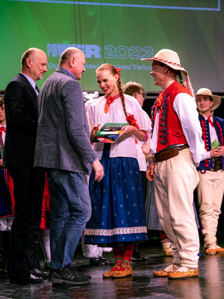 para w strojach ludowych odbierająca dyplom