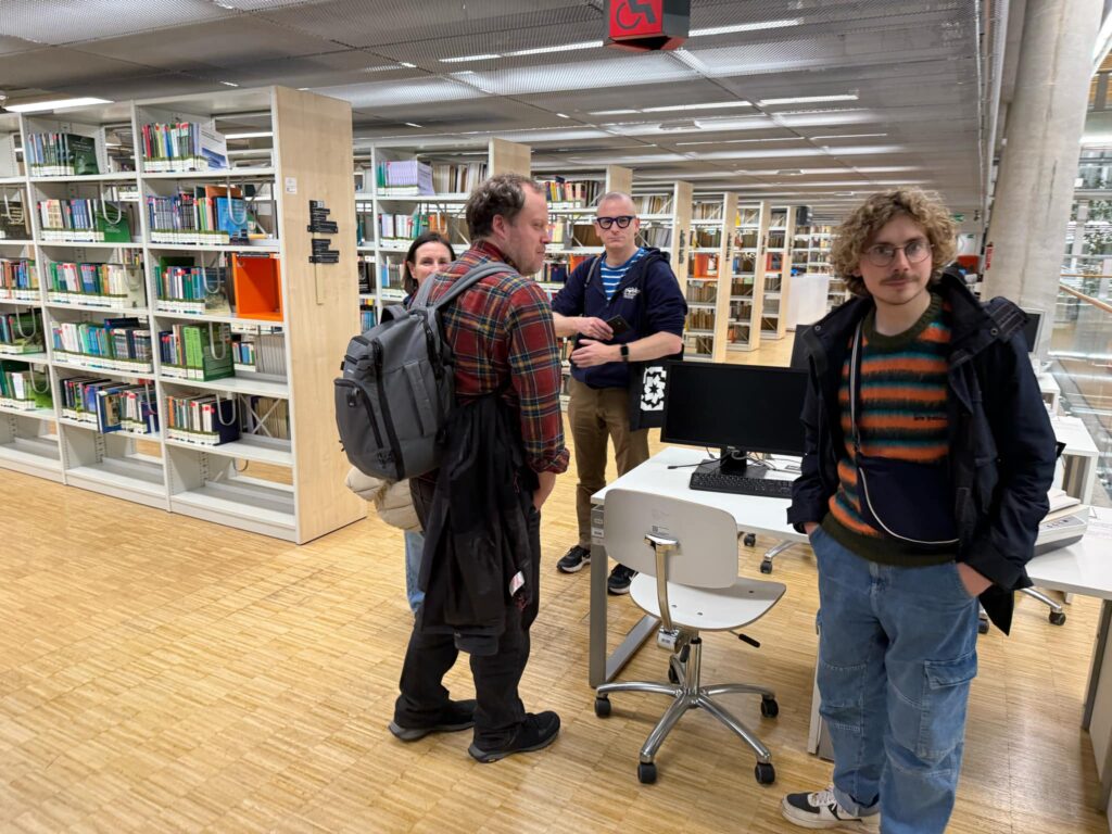 Grupa osób w bibliotece.