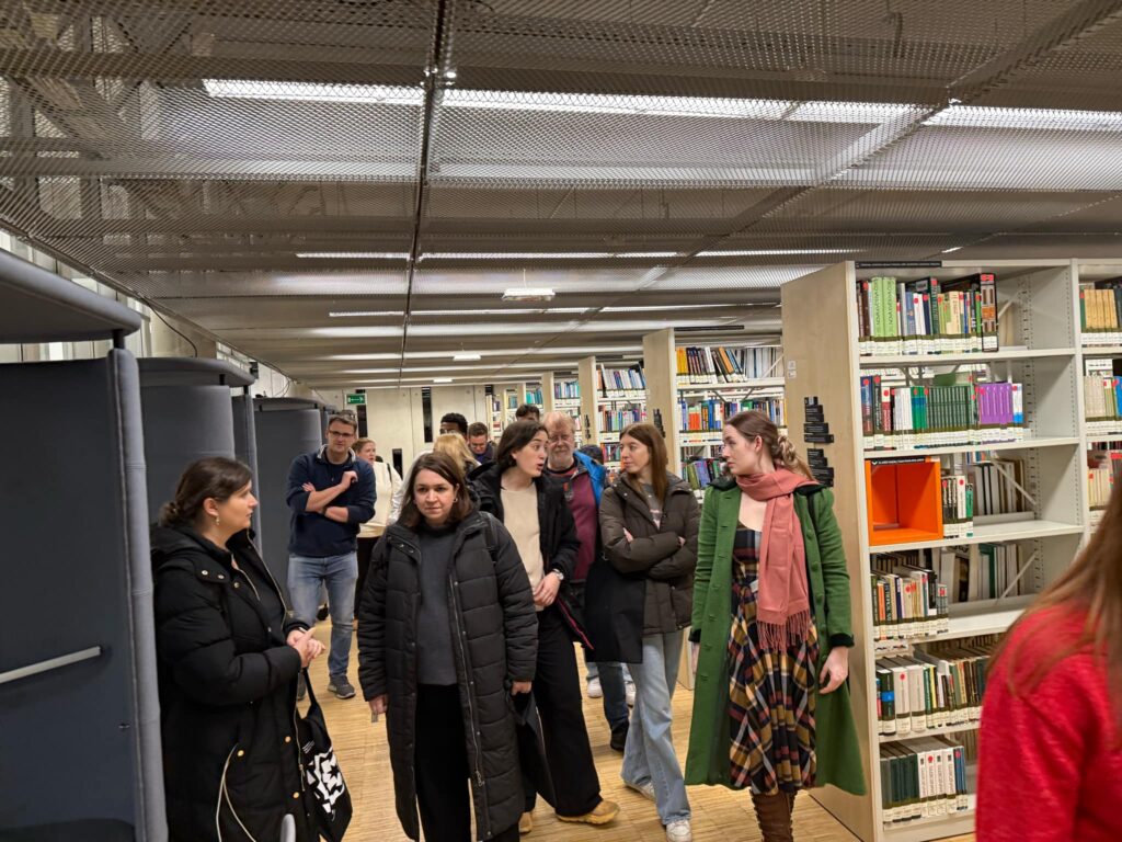 Grupa osób w bibliotece.