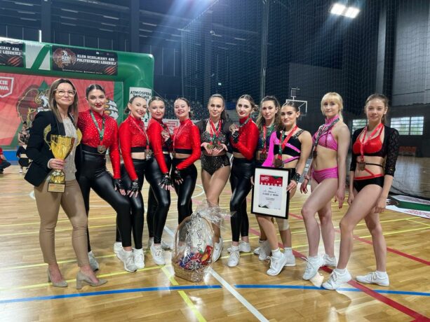 zawodniczki pozujące do zdjęcia z medalami, pucharem i dyplomem