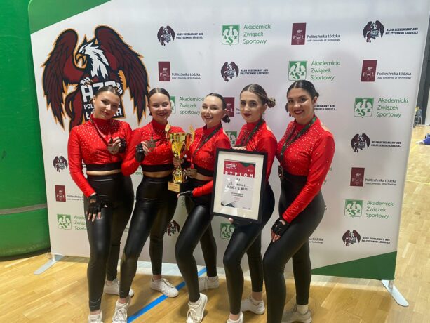 zawodniczki pozujące do zdjęcia z medalami, pucharem i dyplomem