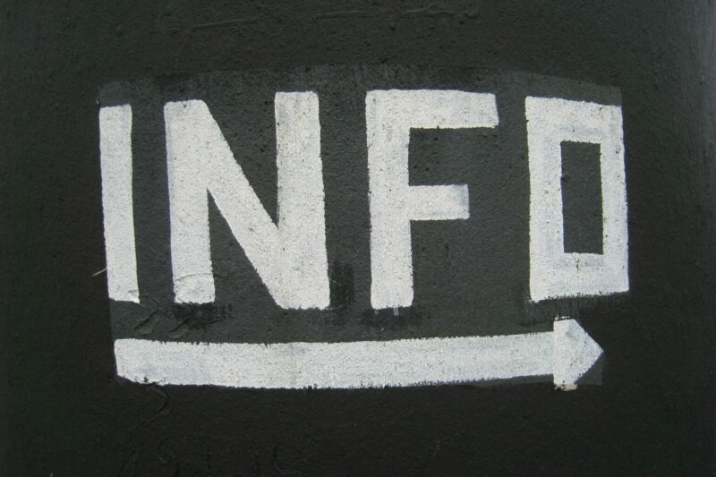 Biały napis "Info" na czarnym tle, pod napisem strzałka kierująca w prawo.
