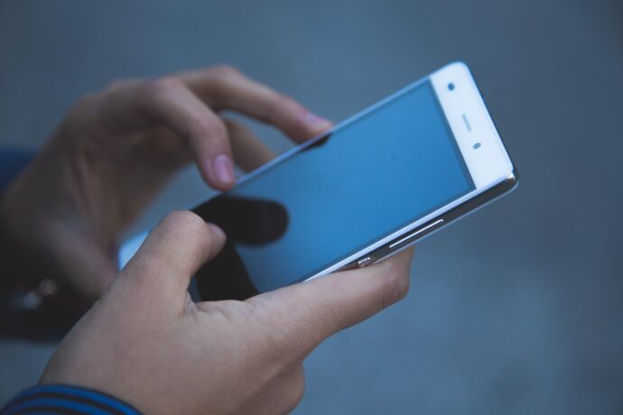 ręce osoby trzymającej telefon komórkowy