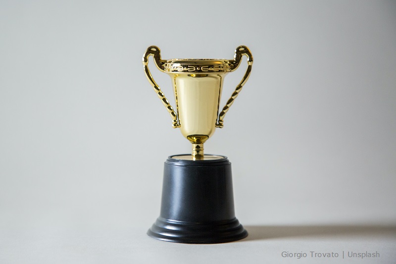 Zwycięski złoty puchar na podstawce umieszczony na białym tle/first prize trophy against white background