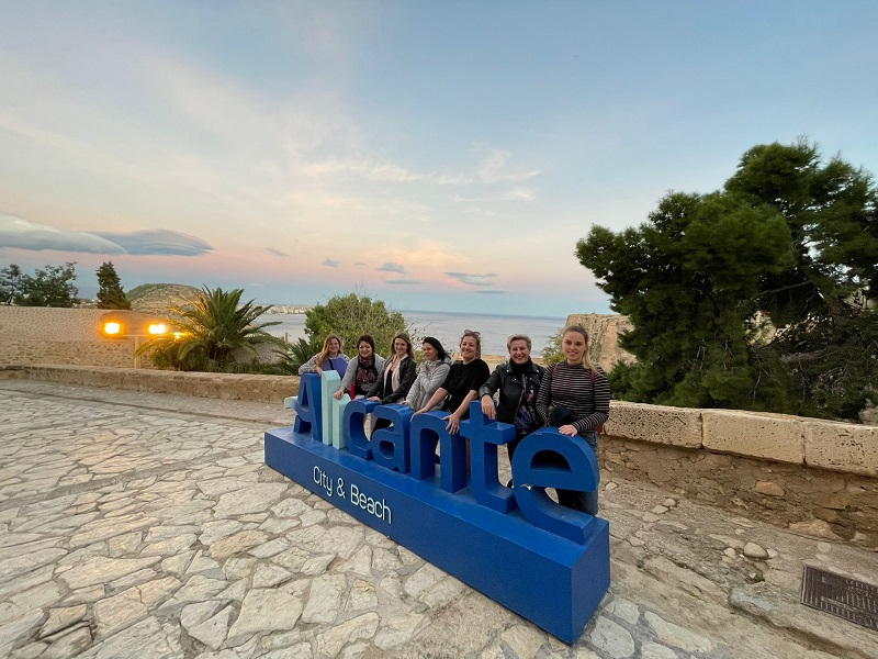 Uczestnicy wizyty pozują grupowo wraz z napisem Alicante