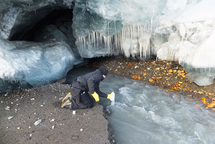 Dr Krystyna Kozioł (from the Polish Polar Station Hornsund – graduate of the University of Silesia) takes water samples from the subglacial river of the Hans Glacier for the chemical composition and mineral suspension testing