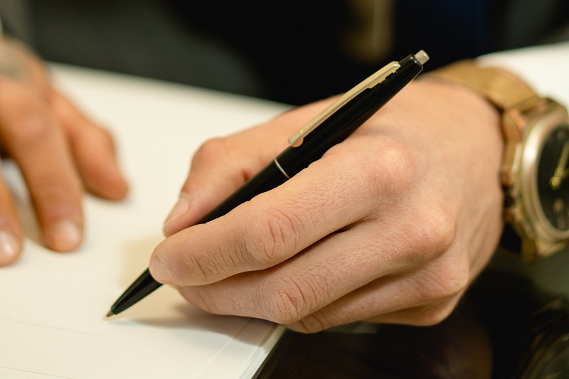 osoba podpisująca dokument, zbliżenie na dłoń