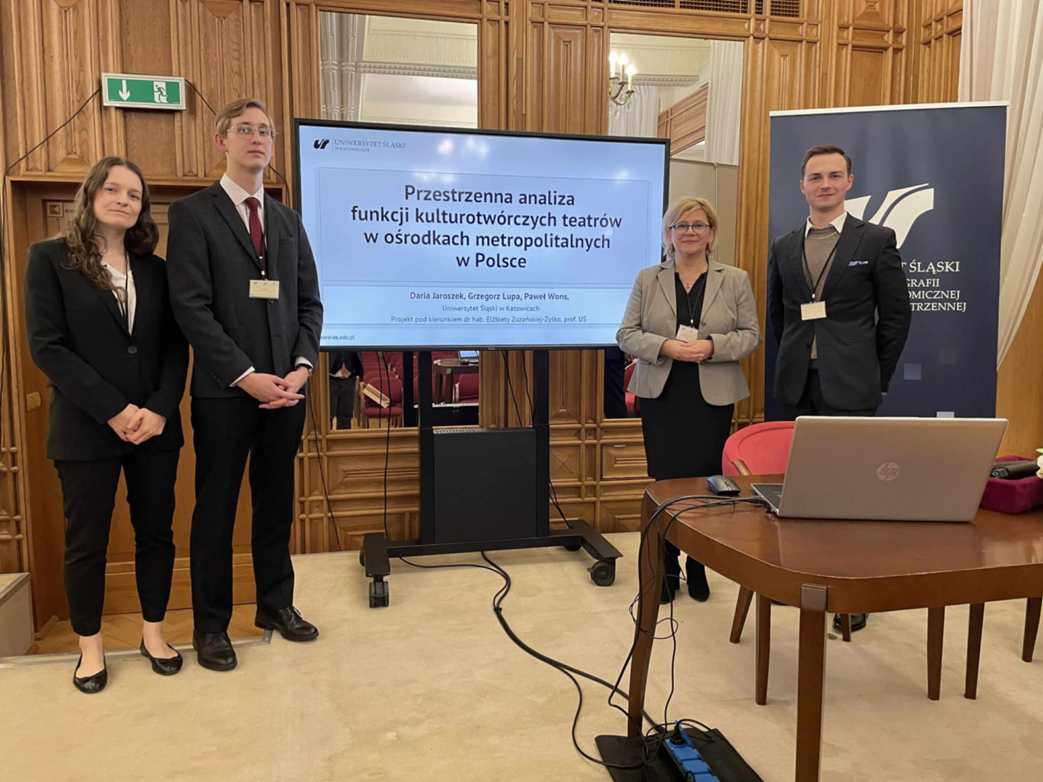 Na zdjęciu uczestnicy wydarzenia przy telewizorze