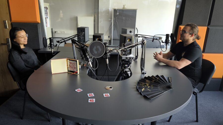 Zdjęcie przedstawia prowadzącego i gościnię podcastu w studiu radiowym na WNS UŚ