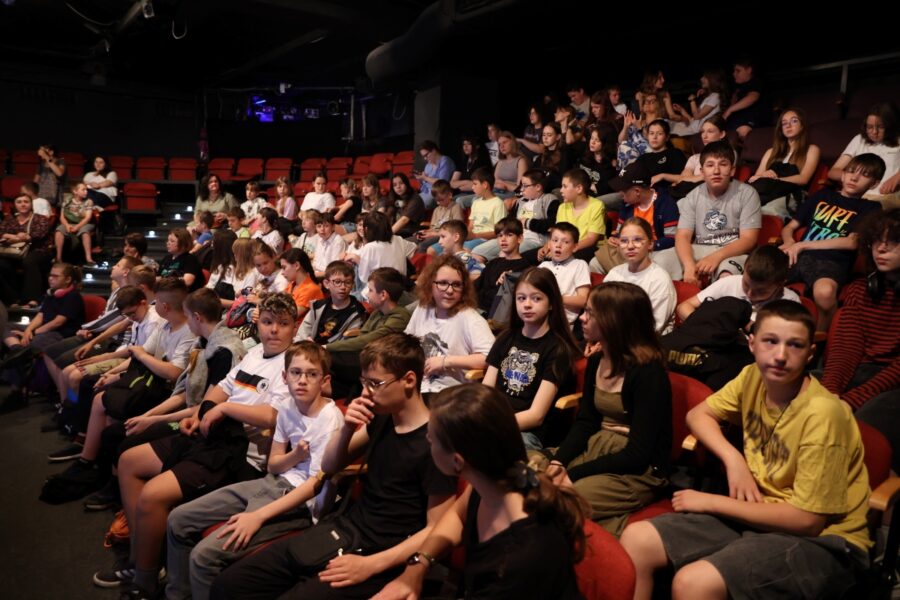 Zdjęcie przedstawia salę teatru korez wypełnioną dziecmi