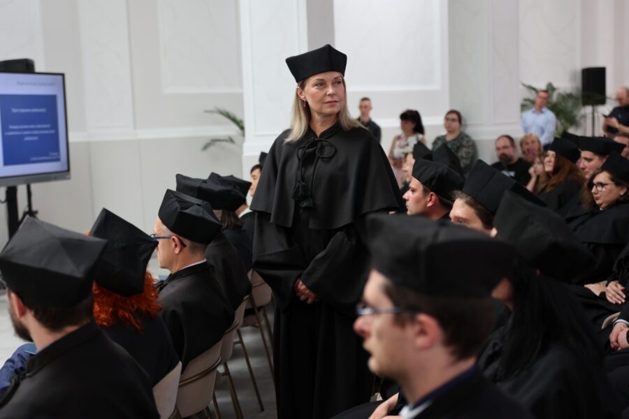 Doktorantka pozuje uśmiechnięta do zdjęcia