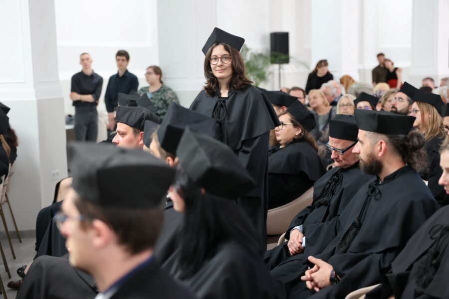 Doktorantka pozuje uśmiechnięta do zdjęcia