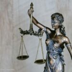 na zdjęciu widnieje rzeźba kobiety, która trzyma wagę