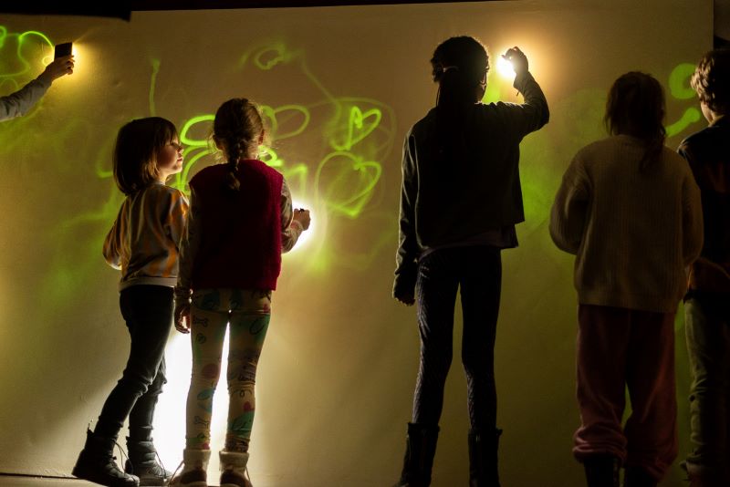 Dzieci rysujące światłem podczas warsztatów w ramach Tygodnia Rysunku