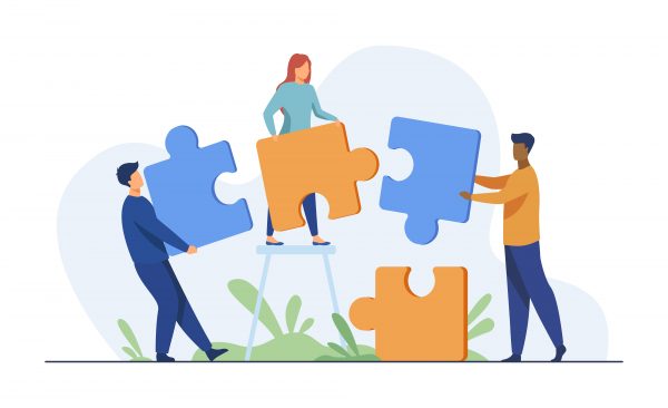Trzy osoby trzymają duże puzzle