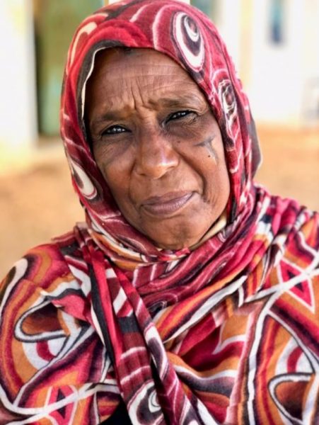 Zdjęcie portretowe Sudanki w kolorowej chuście w odcieniach czerwieni