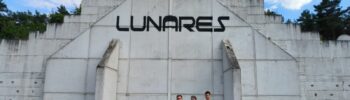 Budynek LunAresu z trzema osobami przed obiektem/LunAresu building with three people in front of the facility