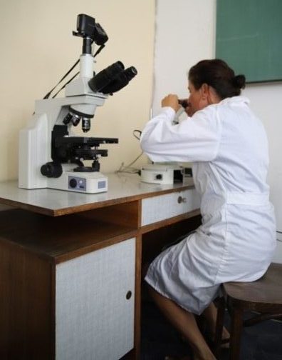 Kobieta siedząca przy mikroskopie