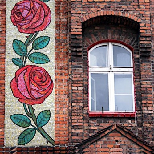 Elewacja kamienicy na Nikiszowcu z mozaiką przedstawiającą pąki czerwonych róż