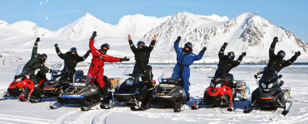 Siedem osób na skuterach śnieżnych na Spitsbergenie