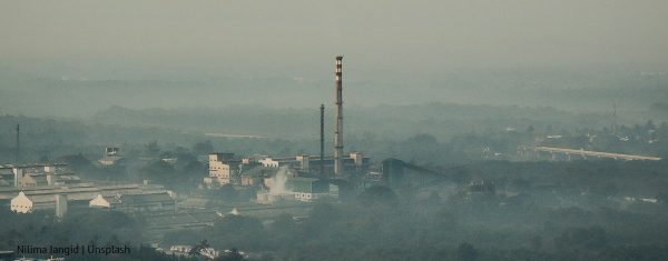 Smog w miejscowości, widoczna fabryka z wysokim kominem