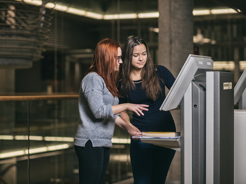 Dwie kobiety szukające informacji w systemie biblioteki