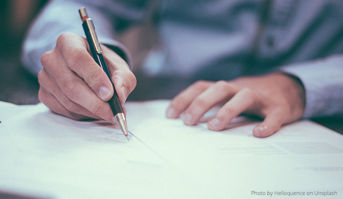 Osoba podpisująca dokumenty, zbliżenie na dłonie/Person signing documents, close-up of hands