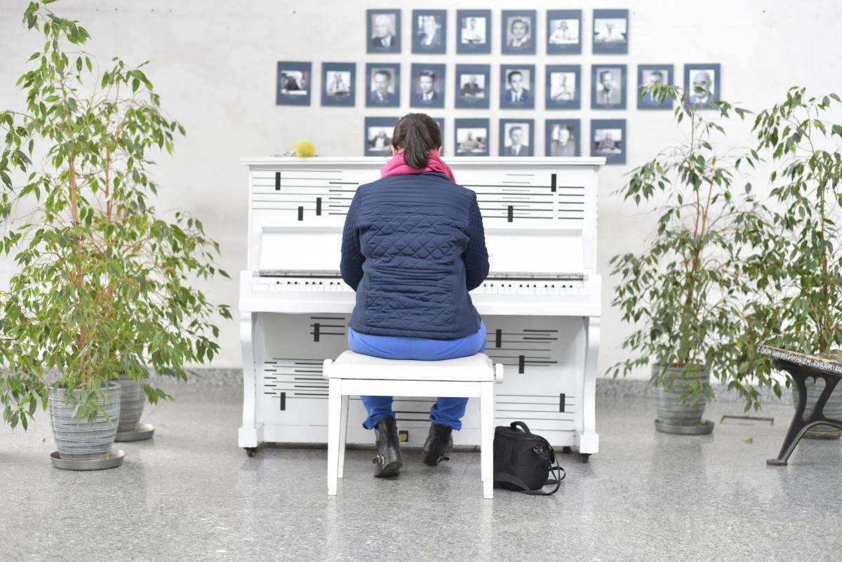 Pianino stojące w holu Wydziału Prawa i Administracji UŚ, osoba grająca 