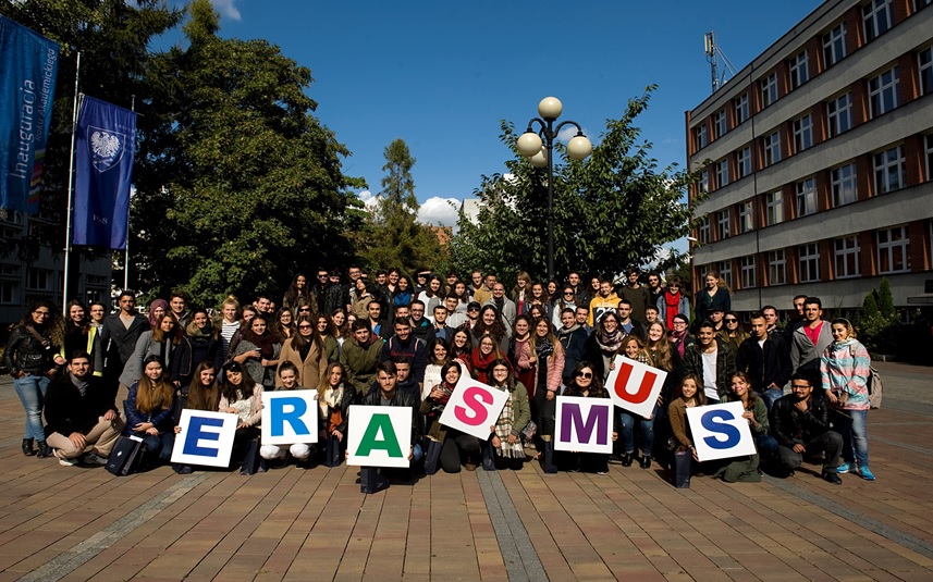 Zdjęcie, na którym jest grupa studentów obcokrajowców trzymająca napis Erasmus+ 