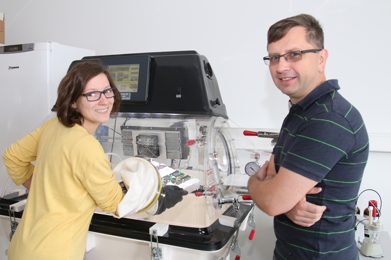 Dr inż. Justyna Knapik-Kowalczuk oraz prof. zw. dr hab. Marian Paluch prezentują działanie Glowboxa – specjalistycznej komory rękawicowej służącej do utrzymywania stałych warunków wilgotności oraz temperatury