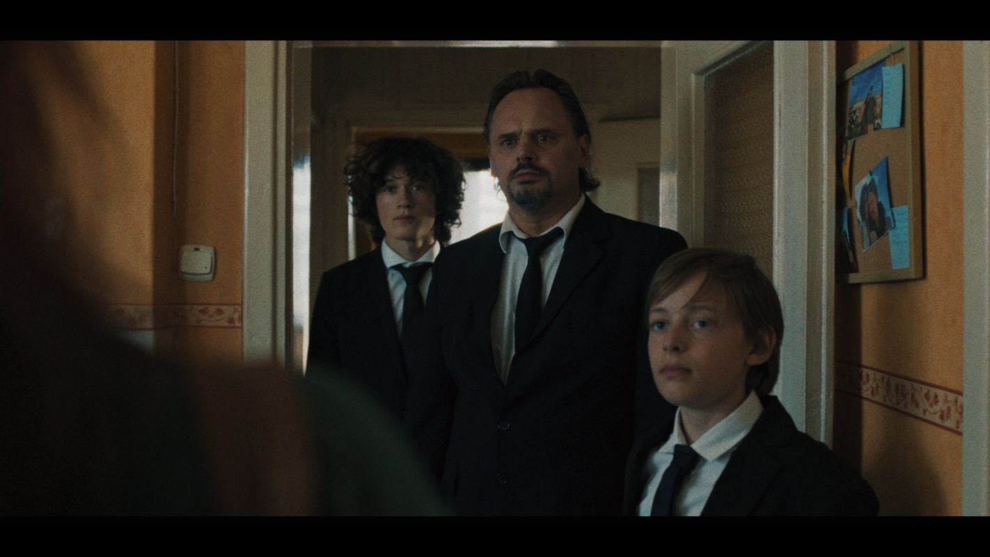 mężczyzna i dwóch chłopaków w garniturach