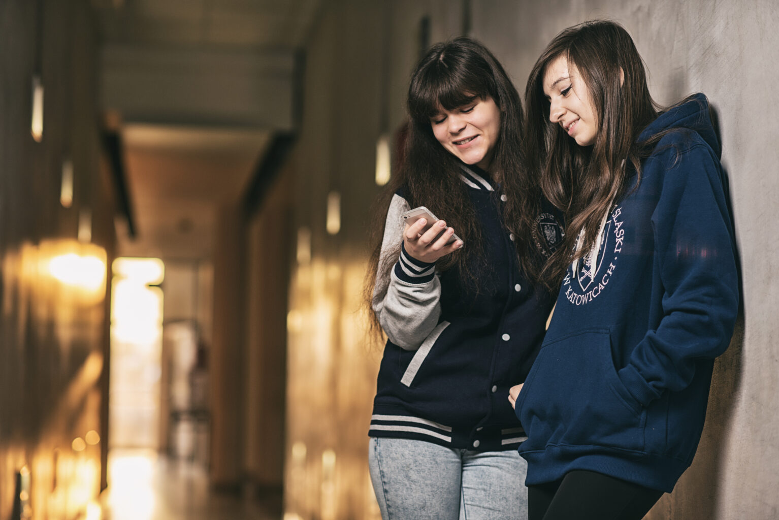Dwie studentki UŚ, oglądają coś na telefonie/Two students of the University of Silesia watching someting on a smartphone