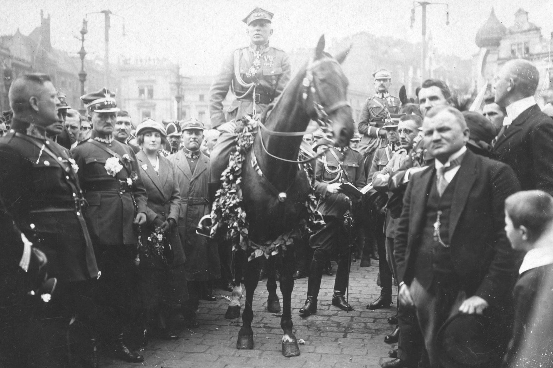 Archiwalne zdjęcie, na którym gen. Stanisław Szeptycki siedzący na przystrojonym koniu, wkroczył do Katowic w 1922 roku. Po jego obydwu stronach tłum ludzi robiących mu przejście