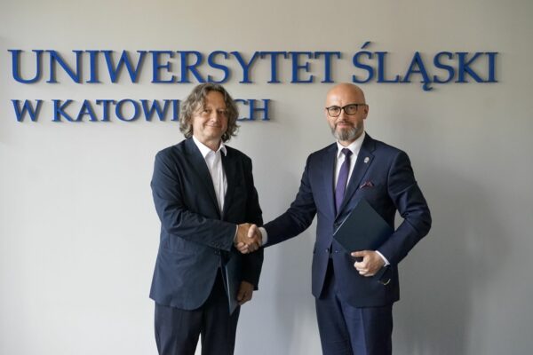 Rektor UŚ prof. dr hab. Ryszard Koziołek podaję rękę szefowi Centralnego Biura Antykorupcyjnego Andrzejowi Stróżnemu. Za nimi napis Uniwersytet Śląski w Katowicach