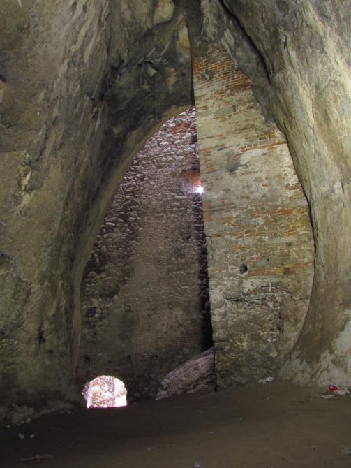 Wysoki na ok. 8 m otwór Jaskini Zamkowej Dolnej zabudowany murem, stan sprzed rozpoczęcia prac wykopaliskowych