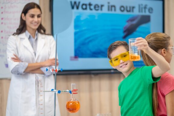 dzieci bawią się z chemikiem w laboratorium